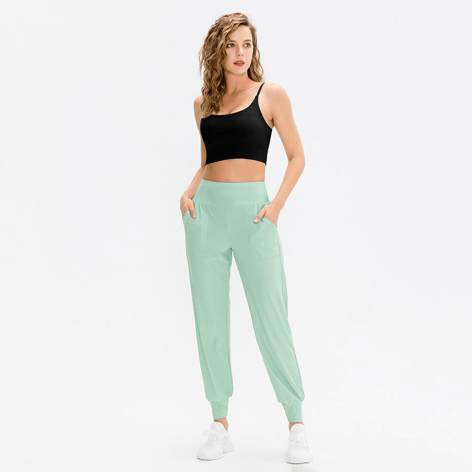 Woman wearing elastic lightweight women's sweatpants with pockets, perfect for yoga and outdoor activities.